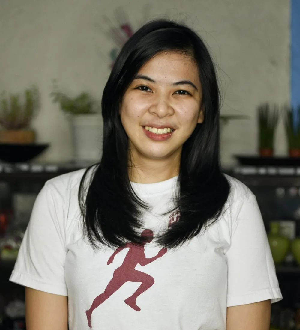 Gillian Alix in a white t-shirt, smiling